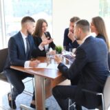 grupa przedsiębiorców rozmawia przy stole